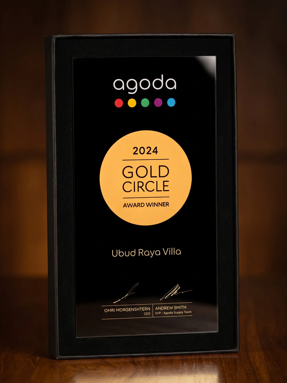 The Agoda Gold Circle Award 2024 plaque, presented to Ubud Raya Villa (Ubud Raya Resort), standing on dark teak