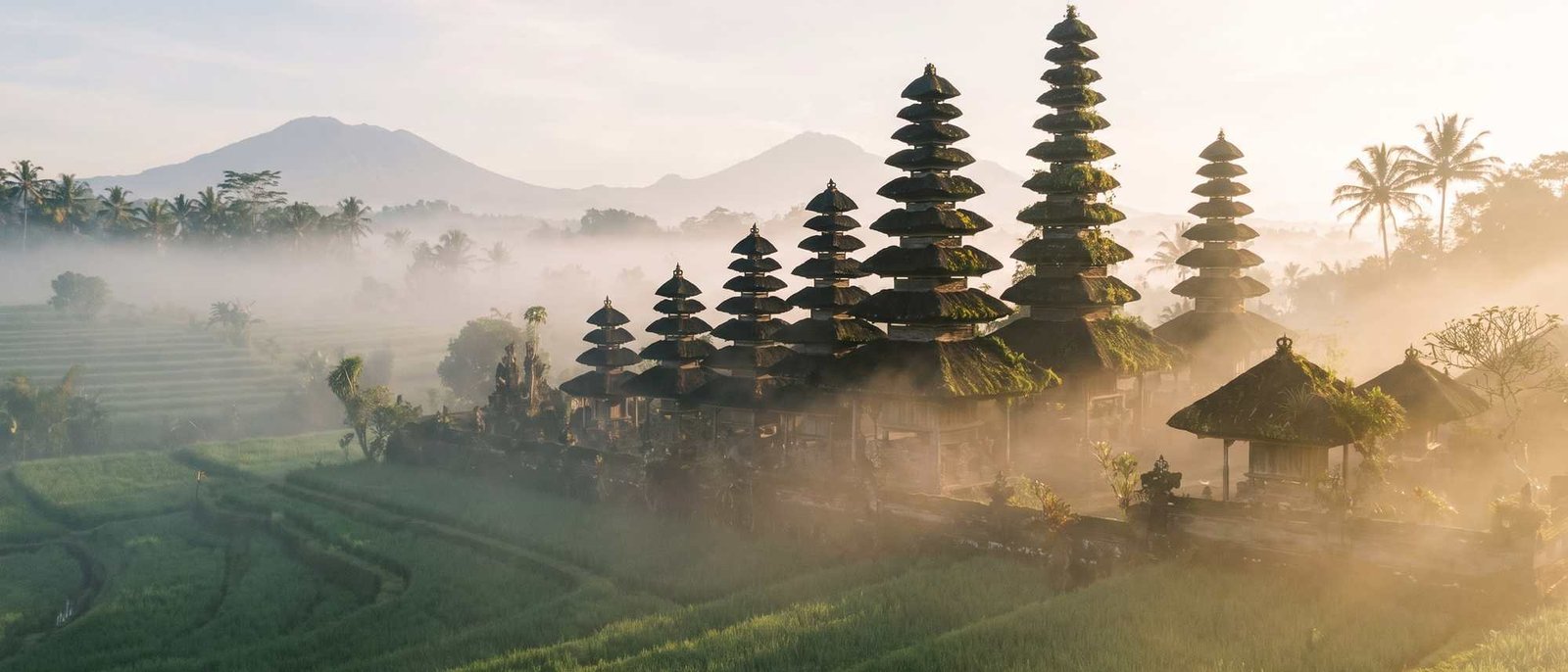 Illustration of tiered meru roofs rising above morning mist, a general Bali scene