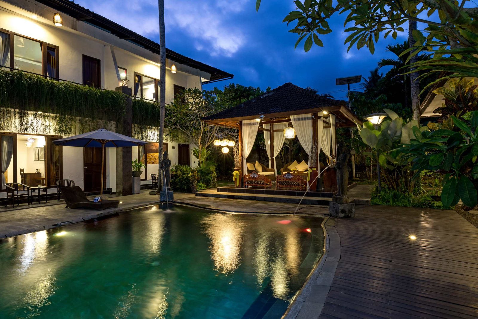 The pool and two-storey room block of Ubud Raya Boutique Hotel at night