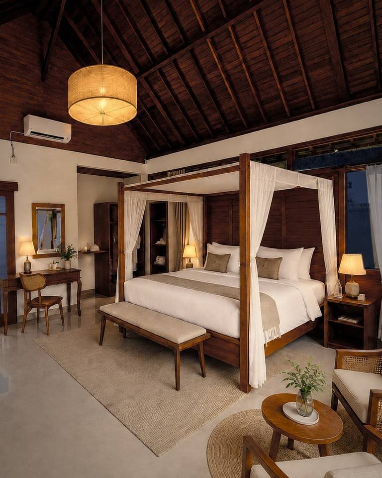 A Villa Rosavelle bedroom: the four-poster bed, the bathtub beyond the sliding door and the chairs by the window