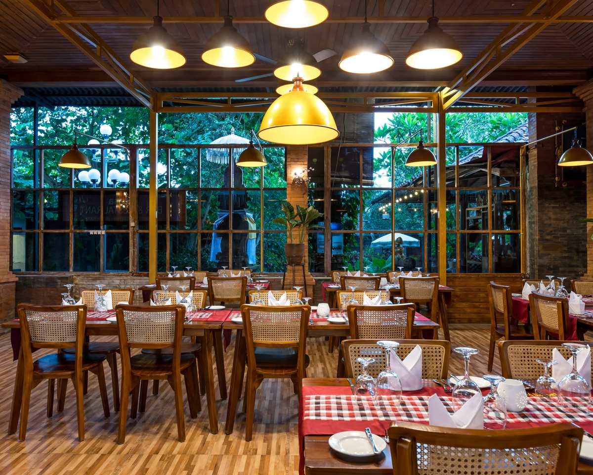 The dining room of Royal Indian Masala with brass lamps and garden windows