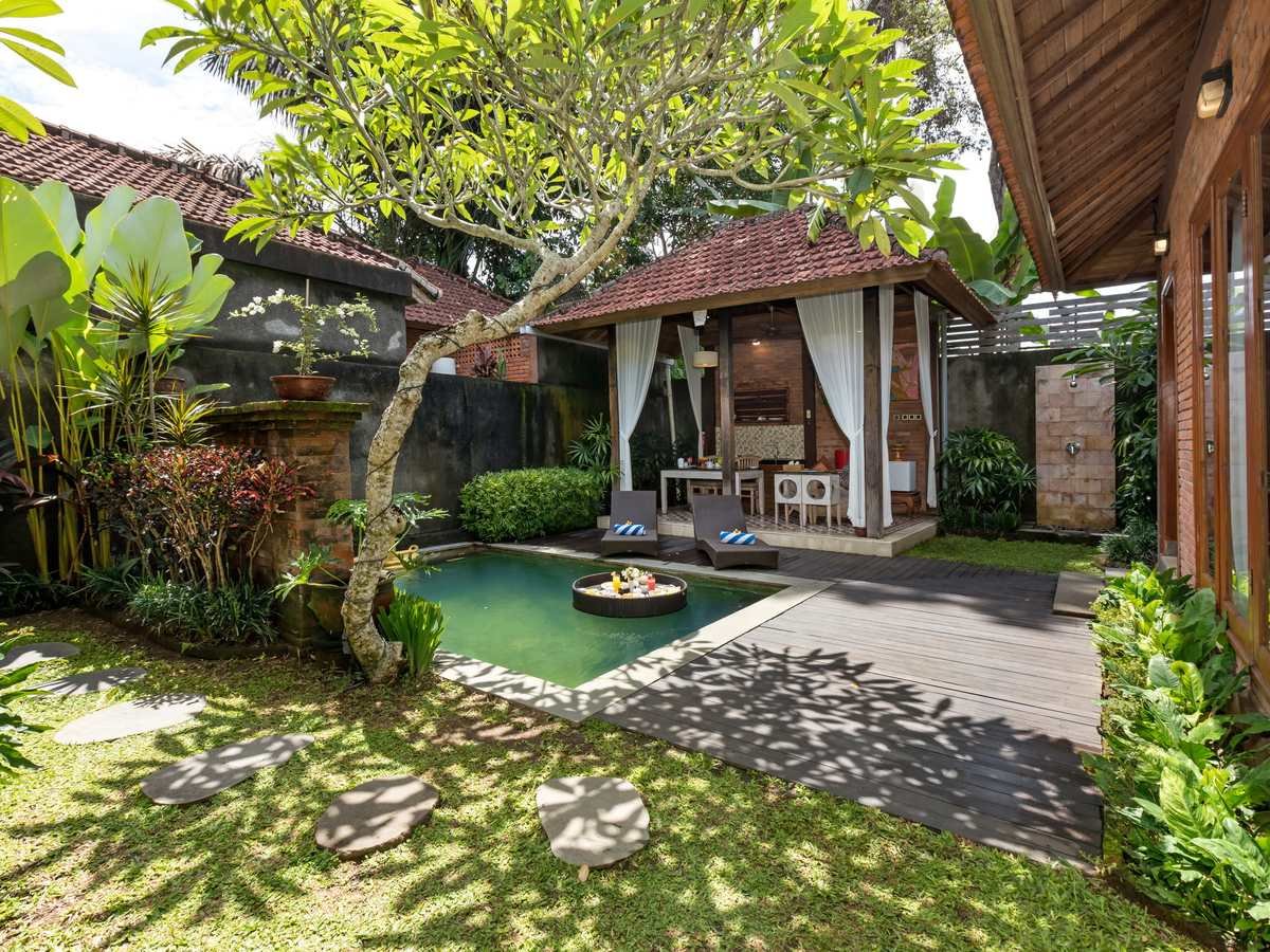 Private pool framed by frangipani and a Balinese pavilion in a one-bedroom villa