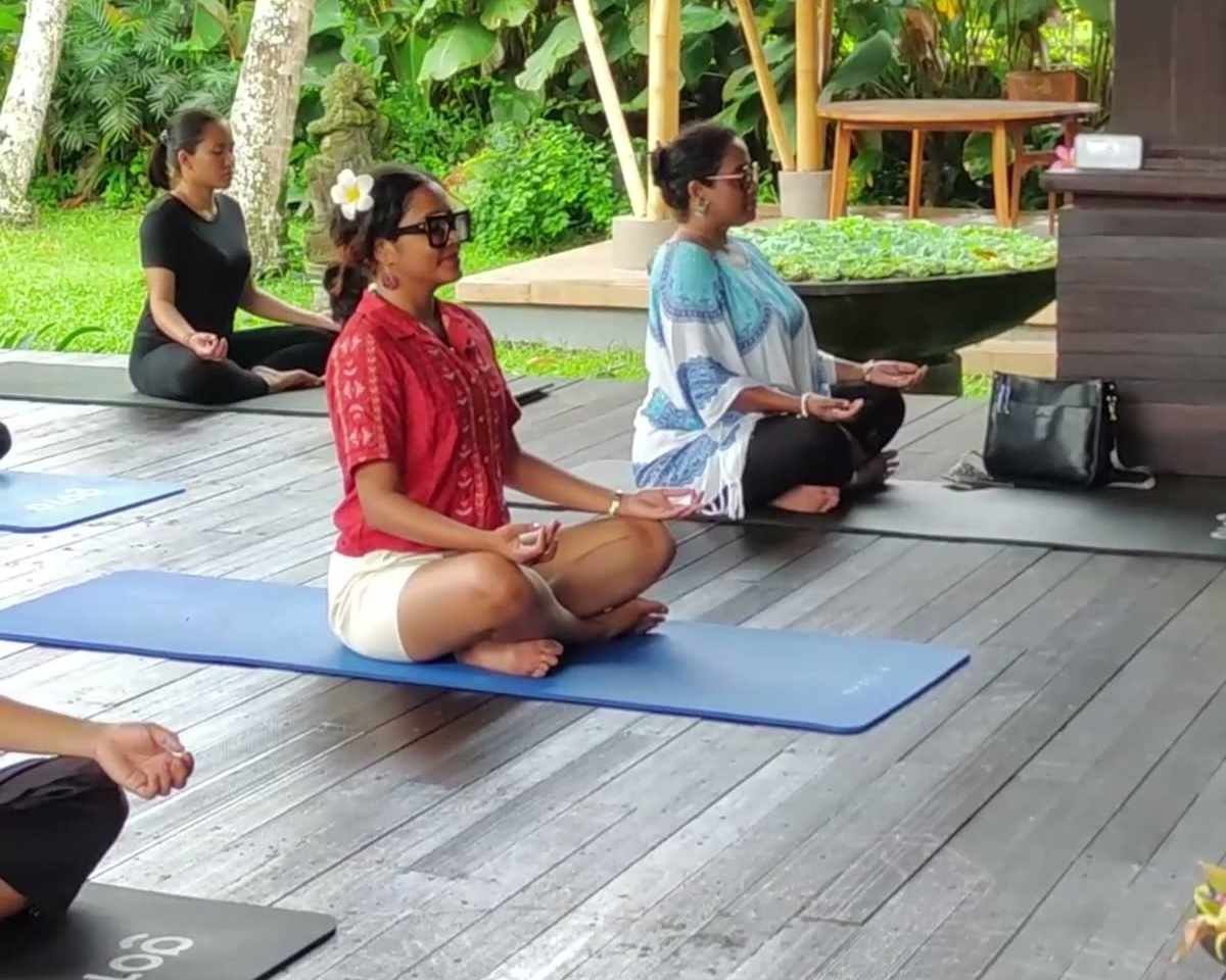 Guests seated in meditation during a yoga class in the pavilion